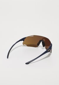 Sports solbriller med mørk marineblå ramme og brune tonede glass. Har en innhyllende design og gumminesegriper for komfort.