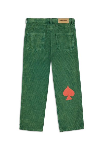 Pantalones de pana verdes con rayas verticales. Presentan dos bolsillos traseros y un gran gráfico de un espade naranja en la pierna izquierda. Etiqueta de marca de cuero en la cinturilla.