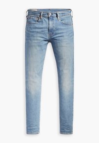 Jean slim bleu clair avec design cinq poches, fermeture bouton et zip, et légère décoloration sur les cuisses et les genoux.