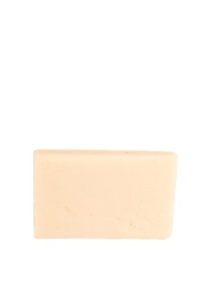 Blocco di sapone beige con una texture liscia, forma rettangolare e bordi leggermente irregolari. Nessun marchio o logo visibile.