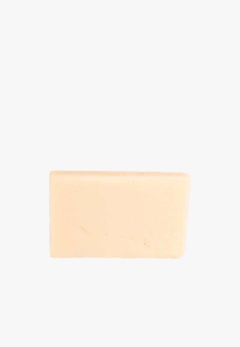 Blocco di sapone beige con una texture liscia, forma rettangolare e bordi leggermente irregolari. Nessun marchio o logo visibile.