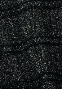 Gros plan sur un tissu noir avec des fils métalliques brillants tissés partout, créant une surface texturée étincelante.