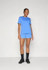 Roupa atlética azul composta por uma camisola de manga curta e calções. Feita de tecido suave, com um corte descontraído e detalhes subtis de costura.