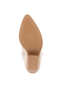 Suela de zapato de tacón alto beige con punta afilada, superficie de goma texturizada y tacón cuadrado. Presenta un acabado sutil y suave, así como líneas de agarre.