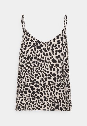 Camisole à bretelles spaghetti avec motif léopard irrégulier noir et blanc sur fond clair.