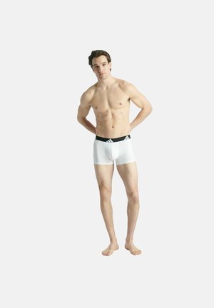 Boxer briefs bianchi con una cintura nera che presenta un logo a contrasto. Il materiale appare liscio ed elasticizzato, aderente al corpo del modello.