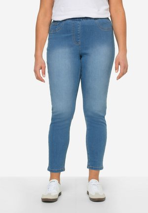 Jean en denim bleu clair avec une coupe slim, taille élastique et deux poches latérales. Texture lisse, avec des décolorations subtiles et des ourlets roulés.