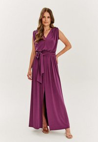 Fialová maxi šaty s hlbokým výstrihom do V, krátkymi rukávmi, viazaným pásom a bočným rozparkom. Vyrobené z hladkej tkaniny s voľným dizajnom.