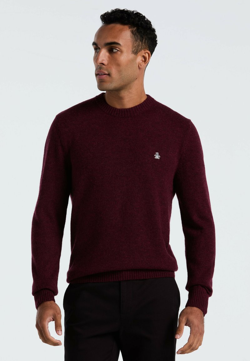 Burgunderfarbener Wollpullover mit geripptem Kragen und Bündchen, ausgestattet mit einem kleinen Logo-Detail auf der Brust. Klassische Passform und glatte Textur.