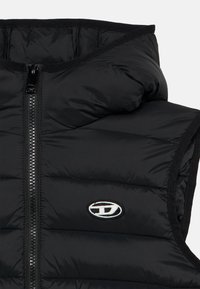 Μαύρο γιλέκο με επένδυση και κουκούλα, με φερμουάρ μπροστά, υφή καπιτονέ και λευκό κεντημένο λογότυπο στην αριστερή πλευρά του στήθους.