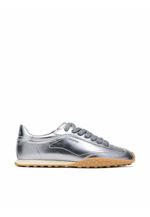 Baskets basses métalliques argentées avec lacets gris et semelle texturée marron clair, vue de côté montrant une tige en cuir lisse et réfléchissante.