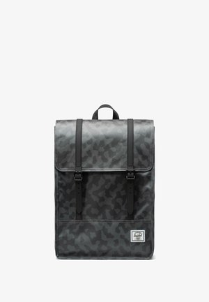 Sac à dos camouflage gris au design structuré, doté de sangles noires et d'une poignée supérieure, fabriqué en matériau durable avec une texture lisse.