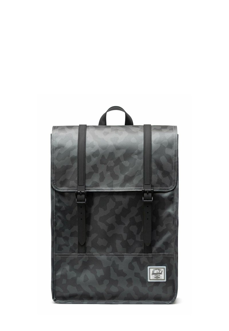 Sac à dos camouflage gris au design structuré, doté de sangles noires et d'une poignée supérieure, fabriqué en matériau durable avec une texture lisse.