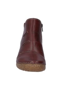 Bottine en cuir bordeaux avec zip latéral, coutures courbées et semelle en caoutchouc brun texturé. Présente des coutures blanches et une finition lisse.