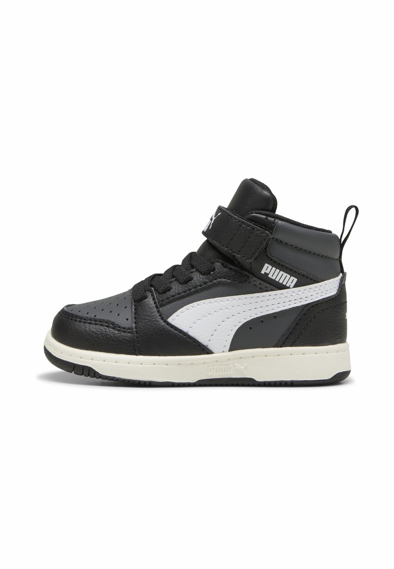 Zapatillas de media altura en blanco y negro con parte superior de cuero, área de puntera perforada, cordones y una correa de velcro, con un distintivo logo de Puma.