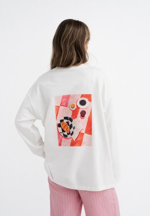 Witte blouse met lange mouwen met een kleurrijke grafische print op de achterkant, met abstracte vormen en een patroonontwerp.