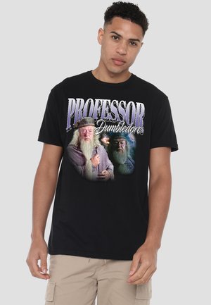 Young man wearing black t-shirt with large images of Professor Dumbledore and text "Professor Dumbledore" in purple and white letters.