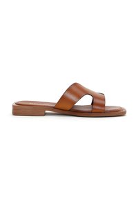 Sandalo in pelle marrone con una larga fascia incrociata, suola piatta e una finitura liscia. Caratterizzato da un design minimalista e stile open-toe.