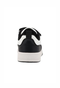 Baskets noir et blanc avec un corps en cuir lisse, des accents texturés noirs, un col rembourré et une semelle en caoutchouc blanche.