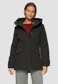 Schwarze wasserdichte Jacke mit hohem Kragen, Reißverschluss und großen Fronttaschen. Verfügt über eine Kapuze und verstellbare Bündchen. Glatte Textur.