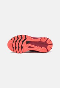 Suela de zapatilla de correr con surcos profundos y acentos negros, diseñada para tracción y flexibilidad, en colores coral brillante y rojo oscuro.