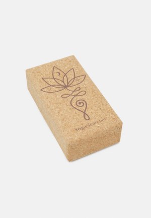 Cork yoga block with a rectangular shape, featuring a brown lotus design and engraved text "YogaSearcher." Smooth texture, natural color.