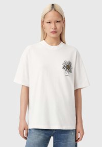 Wit katoenen T-shirt met een madeliefjesdesign op de borst, korte mouwen, een ronde hals en een ontspannen pasvorm. Casual stijl.