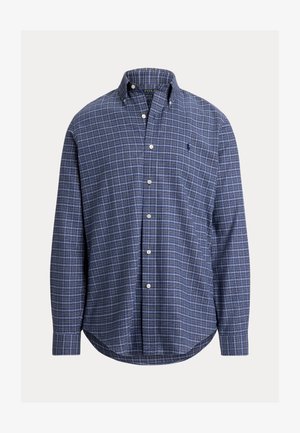 Vīriešu garo piedurknju pogājamo krekliņu tumši zilā krāsā ar režģa rakstu. Izgatavots no šūnveida auduma, kas raksturīgs ar klasisku apkakli un krūšu kabatu.