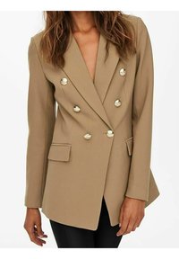 Beżowa dwurzędowa marynarka z błyszczącymi okrągłymi guzikami, wyciętymi klapami i przednimi kieszeniami. Dopasowany krój z długimi rękawami i usztywnioną konstrukcją.