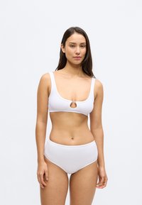 Σετ λευκό μπικίνι με κροπ τοπ που έχει κεντρική λεπτομέρεια με άνοιγμα σε σχήμα κλειδιού και σλιπ με ψηλή μέση, κατασκευασμένο από απαλό, ελαστικό ύφασμα.