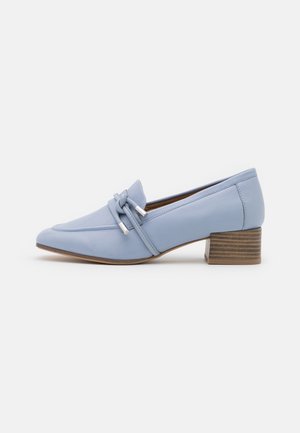 Chaussure en cuir bleu clair avec un bout pointu, nœud décoratif avec des accents argentés, et un petit talon empilé de style bois.