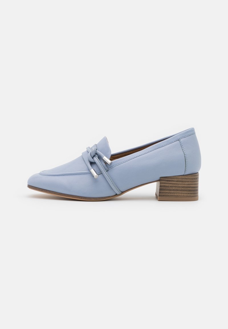 Chaussure en cuir bleu clair avec un bout pointu, nœud décoratif avec des accents argentés, et un petit talon empilé de style bois.