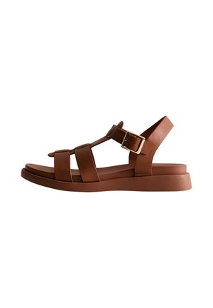Sandales en cuir brun avec plusieurs lanières, un accent de boucle et une semelle épaisse et plate. Texture lisse et design ouvert à l'arrière.