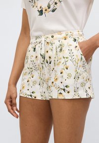 Φλοράλ σορτς σε κρεμ απόχρωση με κίτρινα και πράσινα βοτανικά σχέδια, διαθέτουν ελαστική μέση και πλαϊνές τσέπες. Απαλή βαμβακερή ύλη.