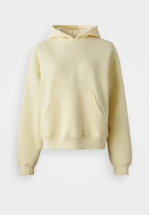 Lys gul cropped hettegenser laget av mykt stoff, med en frontlomme, ribbede ermer og en dobbel-laget hette.