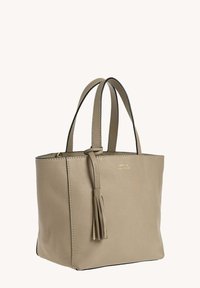 Sac fourre-tout en cuir beige avec des poignées doubles, un détail de pompon et un logo de marque doré subtil à l'avant.