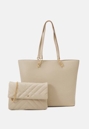 Sac cabas beige avec doubles poignées et pochette matelassée assortie avec une bandoulière chaîne dorée et petits détails de logo dorés.