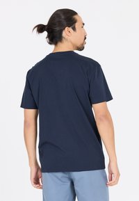 Navy sininen puuvillapaita, jossa on klassinen pyöreä kaula-aukko ja lyhyet hihat, esitetty takaa, jossa on sileä pinta.