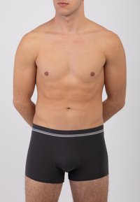 Boxer shorts neri realizzati in tessuto misto cotone. Presentano un elastico a contrasto con righe grigie e un design aderente.