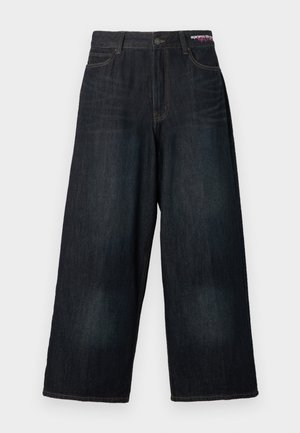 Τζιν με φαρδιά μπόυτ σε σκούρο ντένιμ με αντίθετη κίτρινη ραφή. Διαθέτουν κλασικό σχέδιο με πέντε τσέπες και κουμπιά στο ύψος της μέσης.