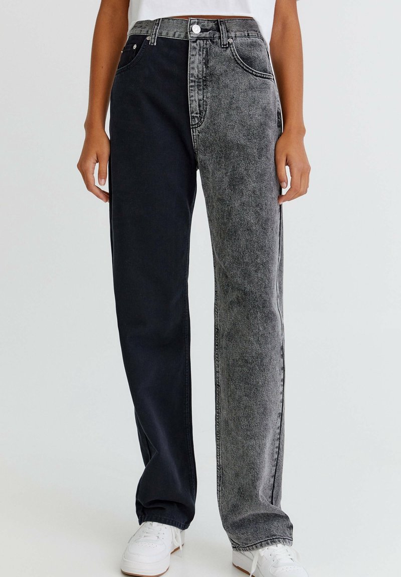 Jeans bicolor que presentan un lado azul oscuro y un lado gris desgastado. Elaborados en denim con un corte recto y un diseño estándar de cinco bolsillos.