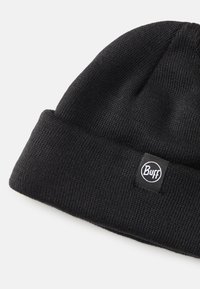 Gorra de punto negra con un dobladillo doblado, que presenta un parche circular con el logo de "Buff". Tejido texturizado con un diseño de punto cerrado.