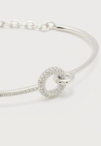 Ασημένιο βραχιόλι με κυκλικό κόσμημα επενδυμένο με μικρούς διαφανείς κρυστάλλους που συνδέει έναν λειασμένο, γυαλισμένο κρίκο με κούμπωμα αλυσίδας.