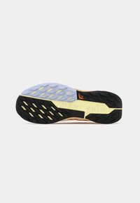De outsole van de Nike Trail-schoen heeft een zwarte rubberen basis met gele accenten, een gestructureerd paars middengedeelte en een gemusterde zool voor grip.
