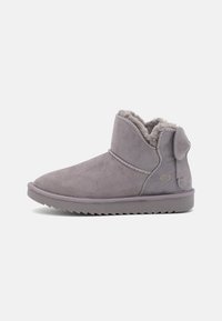Bottes de cheville en suede gris avec une doublure en fourrure douce, bout arrondi et semelle robuste. Présente un design cousu et un détail de tag sur le côté.