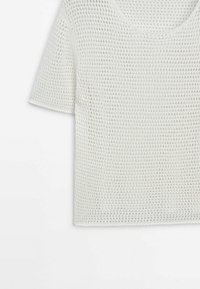Pull en maille blanc à manches courtes avec une texture gaufrée et un col rond, présenté sur fond blanc.