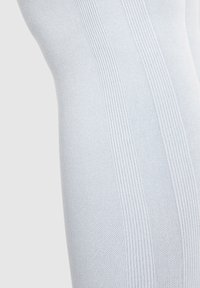 Collant azzurro chiaro a maglia caratterizzati da un motivo testurizzato con righe verticali, realizzati in un materiale morbido ed elastico per garantire comfort.