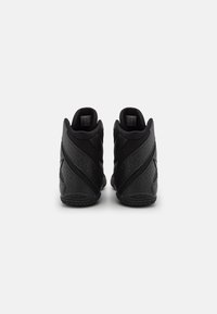 Svart trening sko med høy-topp design, teksturert syntetisk materiale og gummisåler. Har minimalistisk merkevare og nett detaljer.