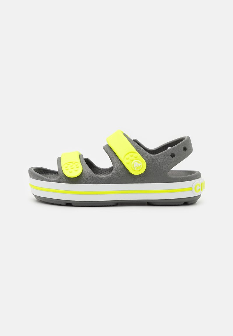 Sandale grise avec deux brides jaunes fluo réglables, semelle blanche avec une bande jaune, et une bride arrière pour le maintien du talon.