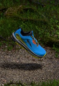 Baskets de sport bleues avec accents noirs, tige texturée, semelle extérieure jaune et lacets multicolores, offrant un design léger pour une utilisation en extérieur.